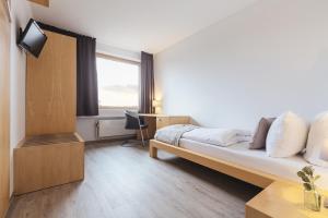ein Hotelzimmer mit einem Bett und einem Fenster in der Unterkunft Novum Akademiehotel Kiel in Kiel