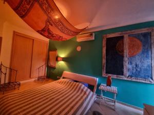 een slaapkamer met een bed en een groene muur bij T1 Falesia in Albufeira