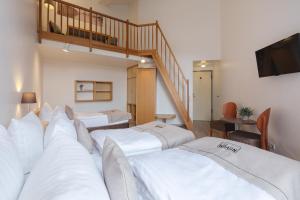 a hotel room with three beds and a staircase at Akademiehotel Kiel in Kiel