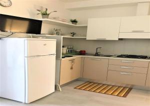 a kitchen with white cabinets and a white refrigerator at Sol Apartament, fronte spiaggia in Silvi Marina