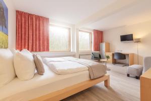 キールにあるNovum Akademiehotel Kielのベッドとテレビが備わるホテルルームです。