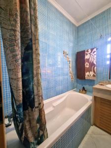een badkamer met een bad en een douchegordijn bij T1 Falesia in Albufeira