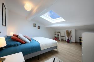 1 dormitorio con 1 cama y tragaluz en L'Ethnique 7p - Climatisation - Jardin - Parking - Salle de Sport en Toulouse