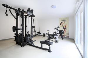 un gimnasio con dos cintas de correr y dos bicicletas estáticas en L'Ethnique 7p - Climatisation - Jardin - Parking - Salle de Sport en Toulouse