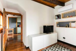 soggiorno con TV su un armadietto bianco di Ca' Pescheria a Treviso