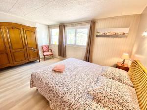 ein Schlafzimmer mit einem Bett, einem Stuhl und einem Fenster in der Unterkunft Villa DAMALIX front de mer 5 pax Plage in Saint-Raphaël