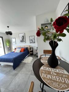 una stanza con un tavolo con un vaso con delle rose sopra di Eclipse Rochelongue a Cap d'Agde