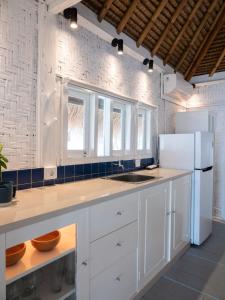 una cucina con armadietti bianchi e frigorifero bianco di Seaside Cottage, Gili Air a Gili Air