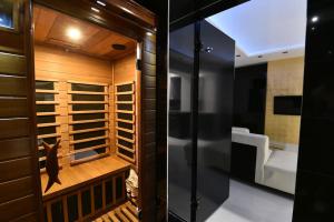 a walk in shower in a bathroom with wooden walls at Lux Spa Apartman na Vračaru in Vračar (historical)