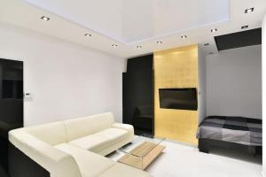 a living room with a white couch and a bed at Lux Spa Apartman na Vračaru in Vračar (historical)