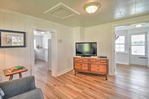 a living room with a television on a wooden dresser at Romantic Waterfront Abode with Patio and Dock! in Deltaville