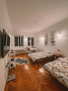 a room with two beds and a table in it at Nina Apartment in Sarajevo