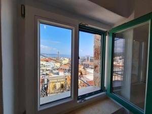 a room with three windows with a view of a city at Gythio townhouse in Gythio