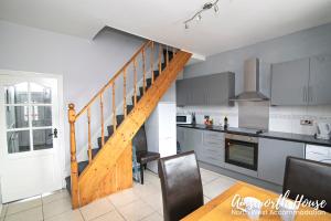 a kitchen with a wooden staircase in a house at Ainsworth House Serviced Accommodation in Bolton