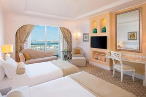 a hotel room with two beds and a television at Habtoor Grand Resort, Autograph Collection in Dubai