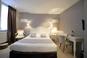 um quarto de hotel com uma cama grande e uma secretária em France Hôtel em Niort