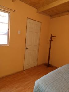 un dormitorio con una puerta blanca y una cruz en la pared en Casa Dorada, en San Pedro de Atacama