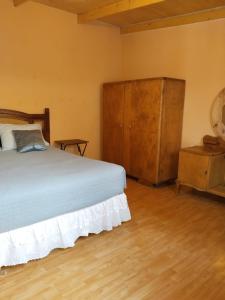 a bedroom with a bed and a wooden cabinet at Casa Dorada in San Pedro de Atacama