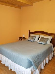 a bedroom with a large bed with two pillows at Casa Dorada in San Pedro de Atacama