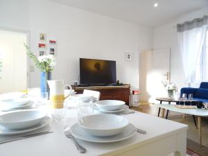 a living room with a table with white dishes on it at Square-bnb - Duplex à 10min de Disneyland Paris in Montévrain