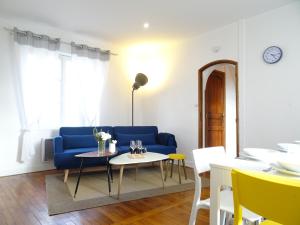 a living room with a blue couch and a table at Square-bnb - Duplex à 10min de Disneyland Paris in Montévrain