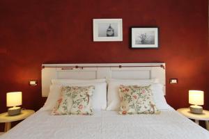 デセンツァーノ・デル・ガルダにあるLa Casa Di Celeのベッドルーム1室(白いベッド1台、ランプ2つ付)