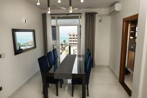 a dining room with a table and chairs and a window at BNB RESIDENCIES MOUNT LAVINIA in Mount Lavinia
