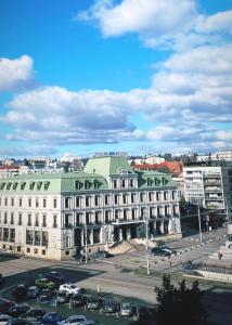 a large white building with a green roof in a city at City Center Apartments - Piața Unirii in Iaşi