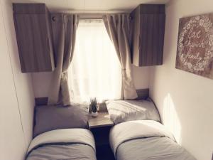 two beds in a small room with a window at The beach retreat, Lido Beach, Prestatyn in Prestatyn