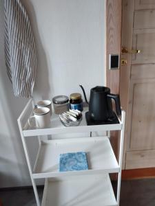 a white shelf with pots and pans on it at Accomodation at Jasmin house in Rødby