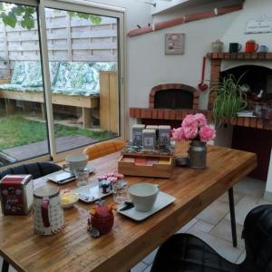 uma mesa de madeira numa cozinha com um estofados de estandartes em Aéroport chambre ,au calme em Bouguenais