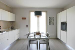 a kitchen with white cabinets and a table with chairs at La Casa Di Cele in Desenzano del Garda