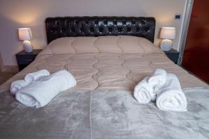 a bed with white towels on it with two lamps at Attic A31 apartament rooftop deluxe in Santa Maria Capua Vetere