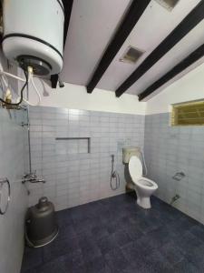 a bathroom with a toilet and a shower stall at Coorg Daffodil Guesthouse in Madikeri