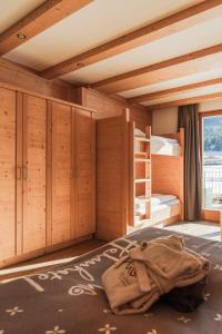 a room with a bed and bunk beds in it at Helmhotel in San Candido