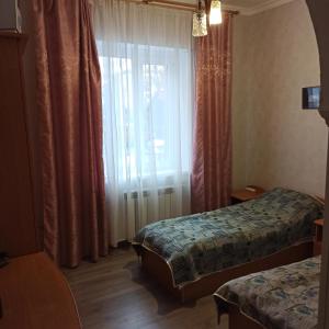 Habitación de hotel con 2 camas y ventana en Готель-хостел en Truskavets