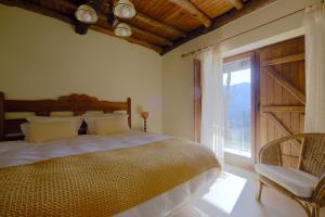 um quarto com uma cama e uma grande janela em Casa da Terra - Gerês no Gerês