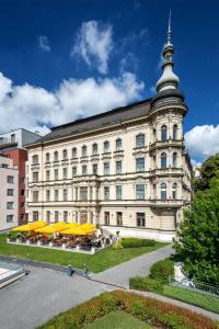 ein großes Gebäude mit gelben Sonnenschirmen davor in der Unterkunft Le Palais Art Hotel Prague in Prag