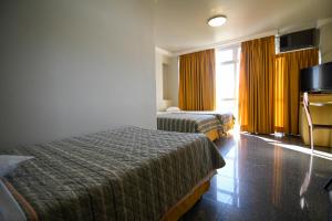 a hotel room with two beds and a television at Like U Hotel Brasília in Brasília +32 photos