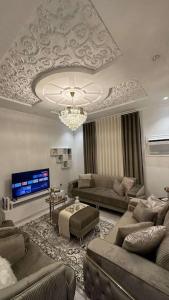 a living room with couches and a chandelier at luxury apartment - Prince majed park in Jeddah