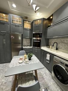 a kitchen with a table with chairs and a sink at luxury apartment - Prince majed park in Jeddah