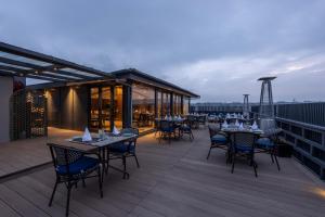 a restaurant with tables and chairs on a deck at Sarovar Portico Srinagar in Srinagar