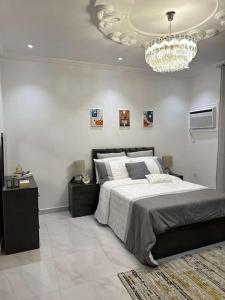 a bedroom with a large bed and a chandelier at luxury apartment - Prince majed park in Jeddah
