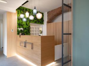 a lobby with a reception desk with a green wall at Avenue Boutique Hotel in Como