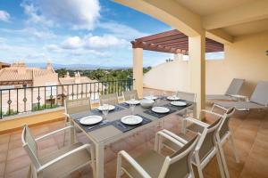 een eetkamer met een tafel en stoelen op een balkon bij Casa Saudade - Luxury penthouse apartment with stunning views in Estômbar