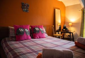 ein Schlafzimmer mit einem Bett mit Eulen auf den Kissen in der Unterkunft Manorbier Castle Inn Sunset Room in Tenby