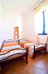 two beds in a room with a window at Piccolo Residence Gallipoli in Gallipoli