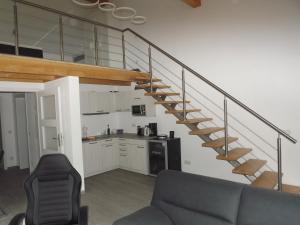 a living room with a couch and stairs in a house at Ferienhaus Am Waldrand - "Libelle" in Tornitz