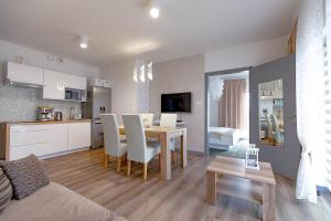 a living room and kitchen with a table and chairs at Apartament & Spa 5 Mórz in Sianozety