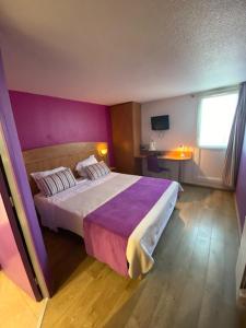 a bedroom with a large bed with a purple wall at Hôtel De La Plage in Calais